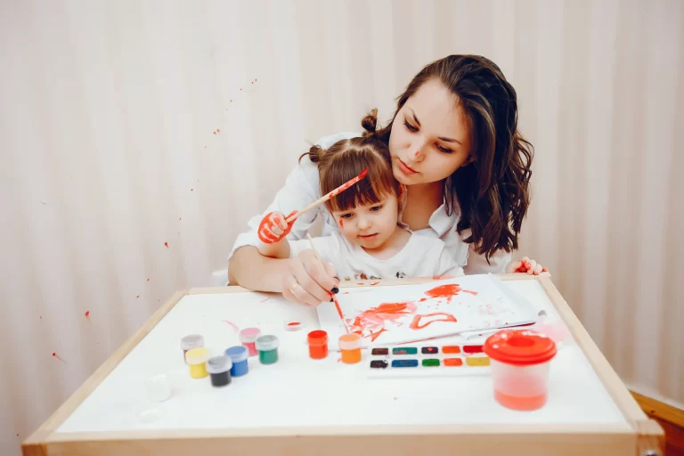 young mother along with her little daughter paints paper 2 3